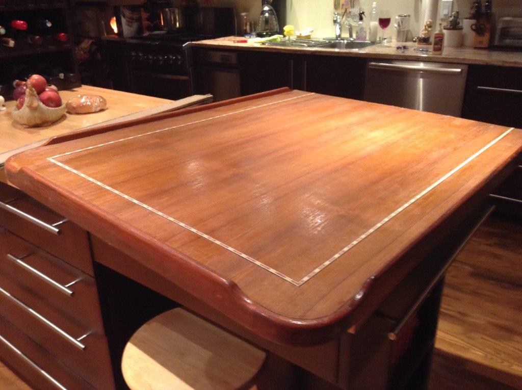 after stripping the old surface, added a teak veneer and a decorative inlay